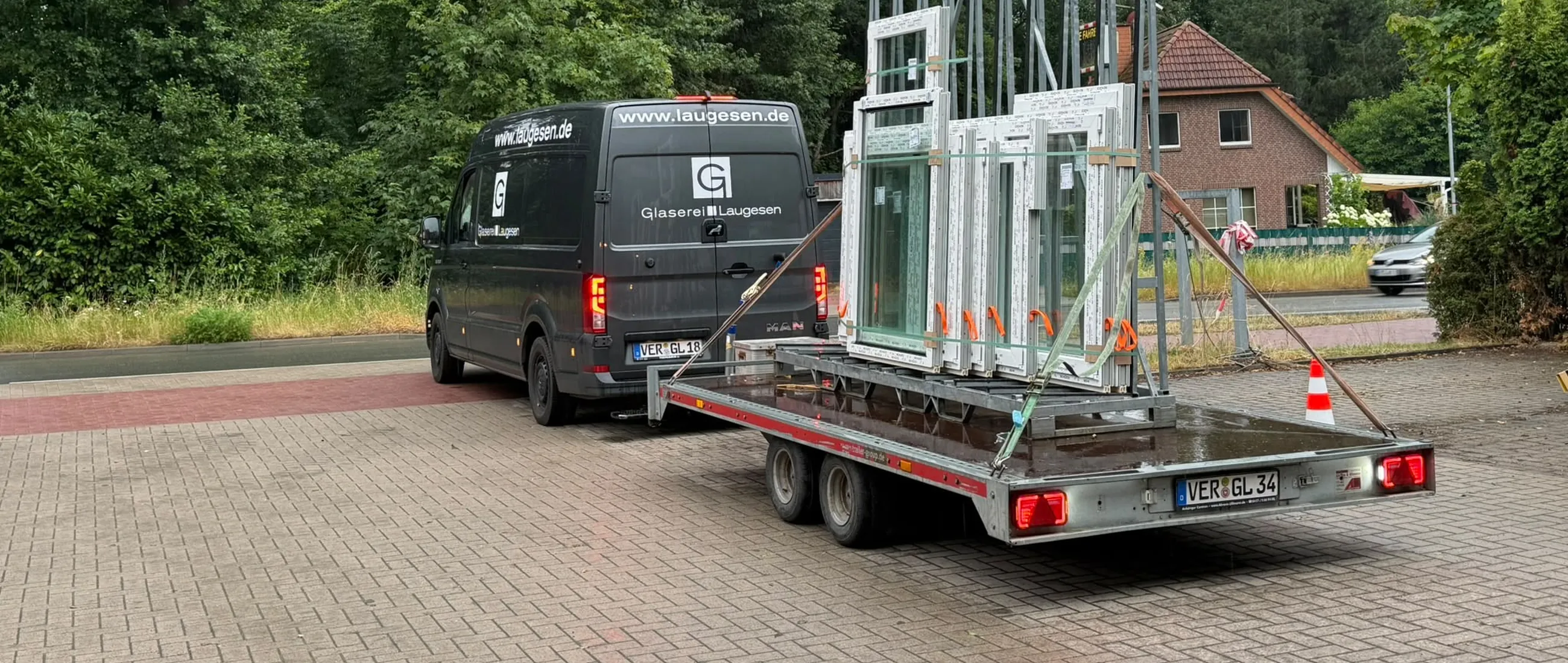Transporter und Anhänger der Glaserei Laugesen mit Fenstern auf dem Weg zur Baustelle