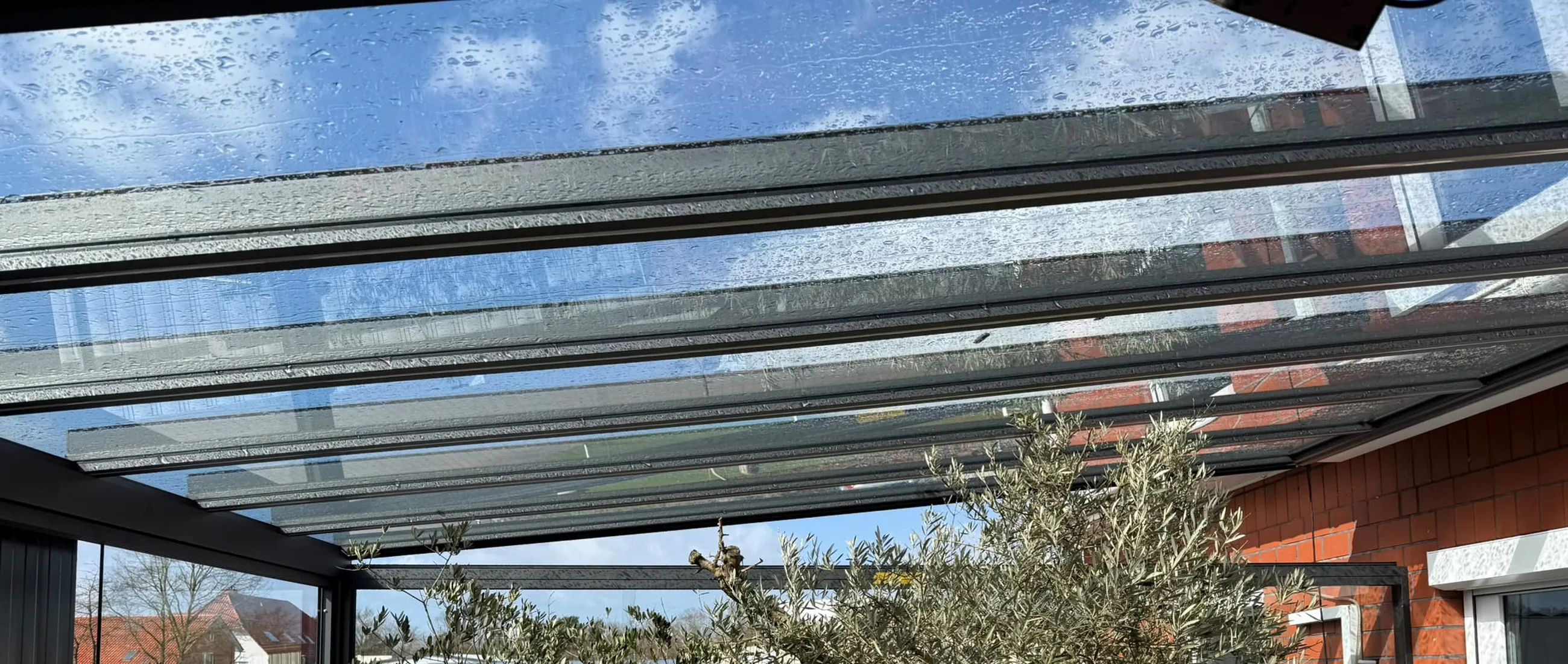 Regentropfen auf der Glaseindeckung eines Terrassendachs der Glaserei Laugesen