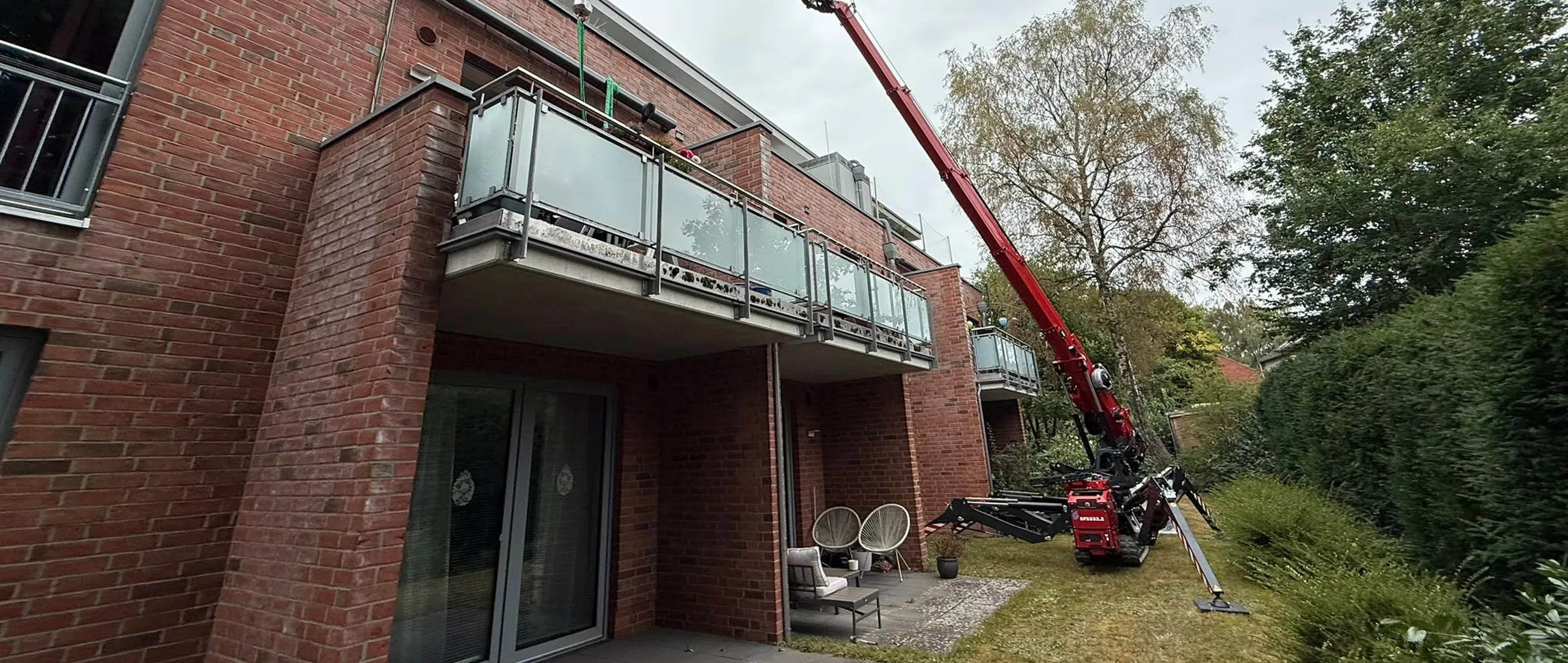 Mini-Kran der Glaserei Laugesen bei der Verglasung an einem Mehrfamilienhaus